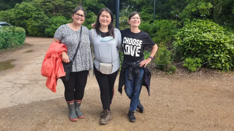 Parents Yvonne, Maria and Rachel are standing together with their arms around each other. 